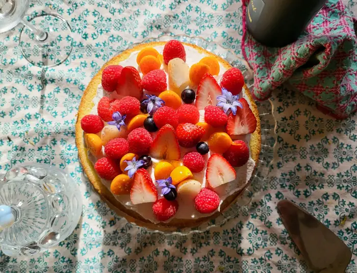 Fresh fruit tart topped with strawberries, raspberries and edible flowers