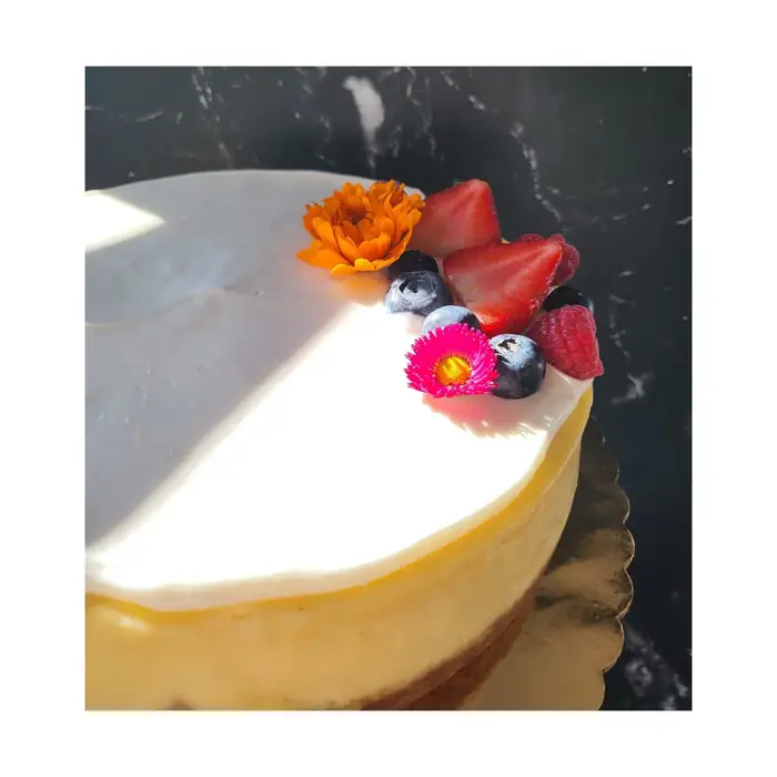Vanilla cheesecake topped with fresh berries and edible flowers