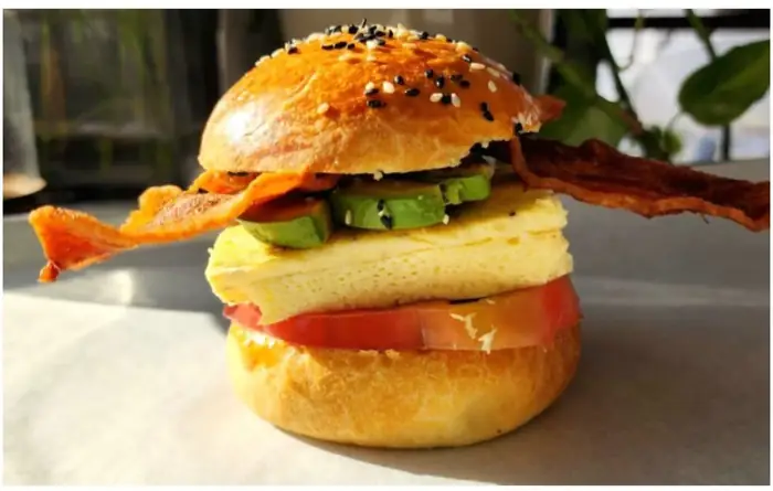 The Eggbun sandwich with bacon, egg, avocado and tomato on a brioche bun
